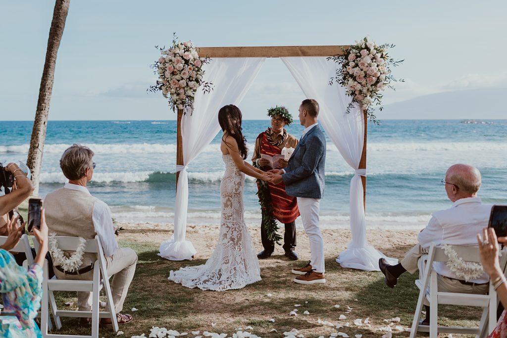 Bride and Groom hand in hand during beach homily Ceremony