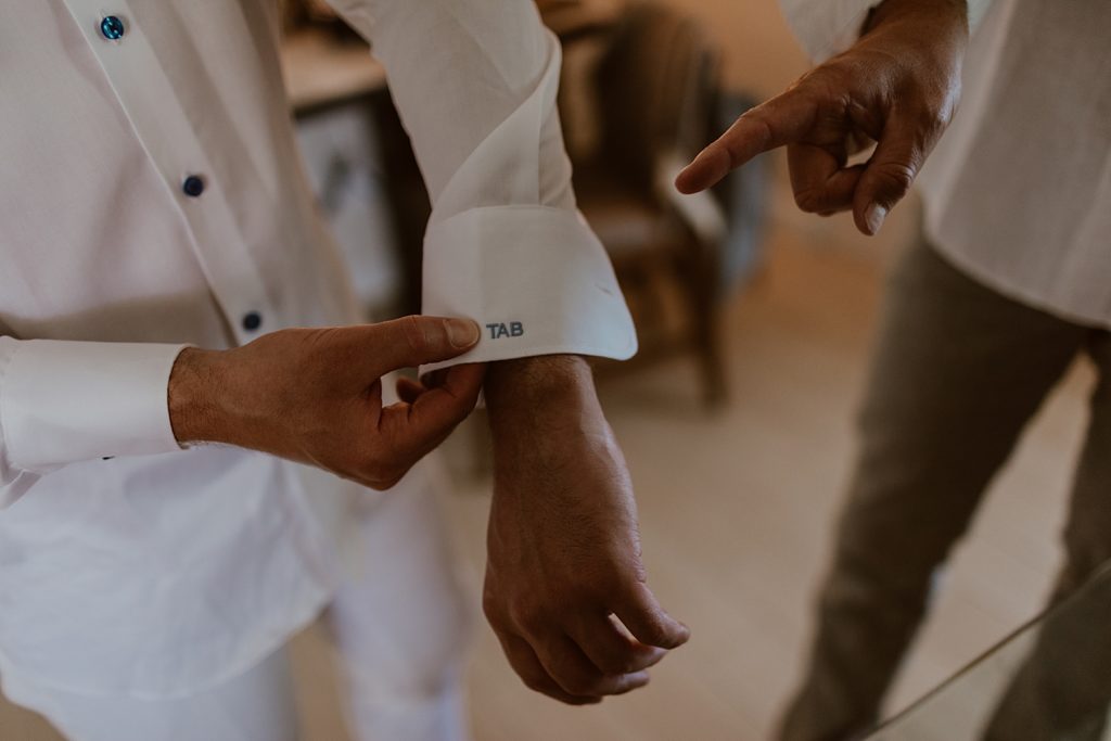Detail shot of groom adjusting sleeve getting ready