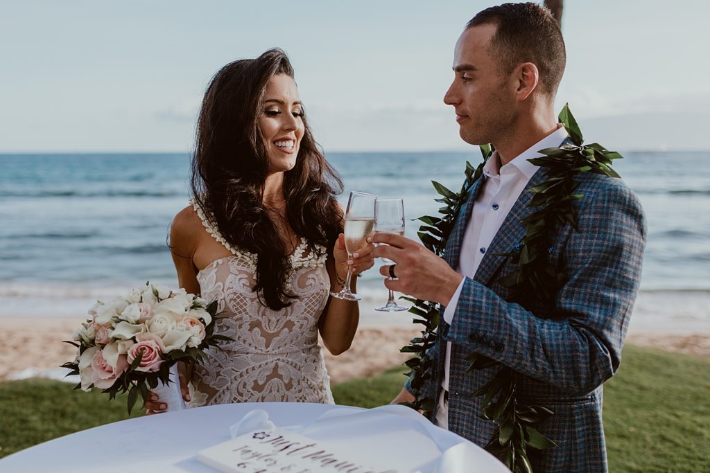 Bride and Groom cheering Champaign glasses after beach Ceremony