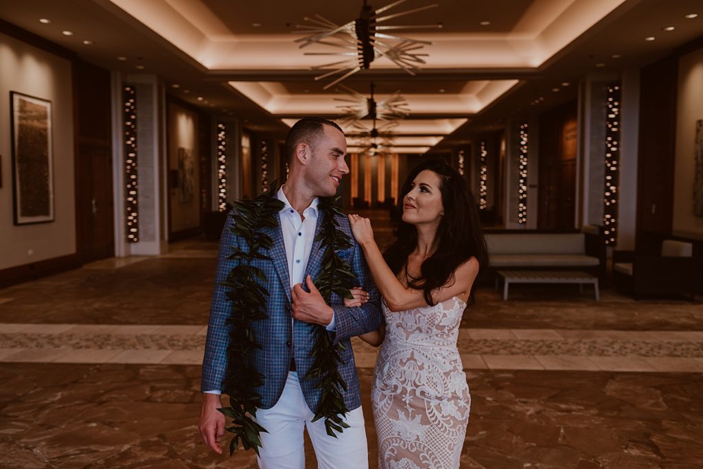 Bride holding Groom's arm in regal hallway