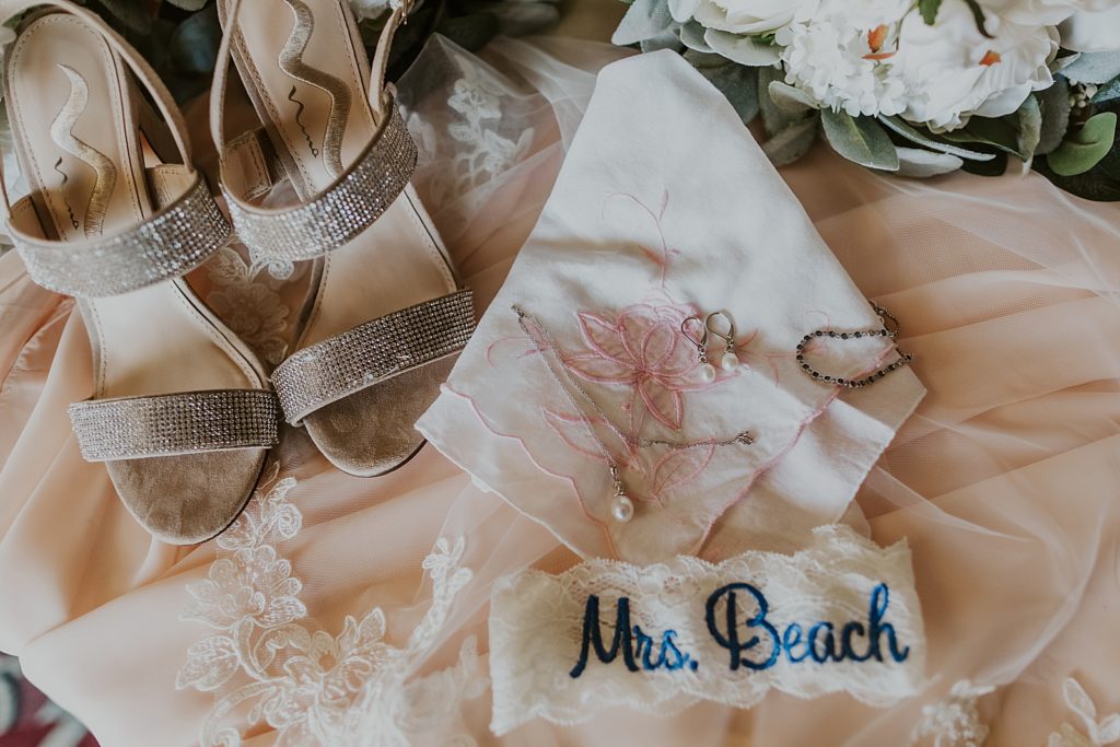 Detail shot of pearl earrings heels and garter