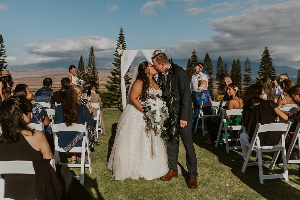 Bride and Groom halfway through exit kissing