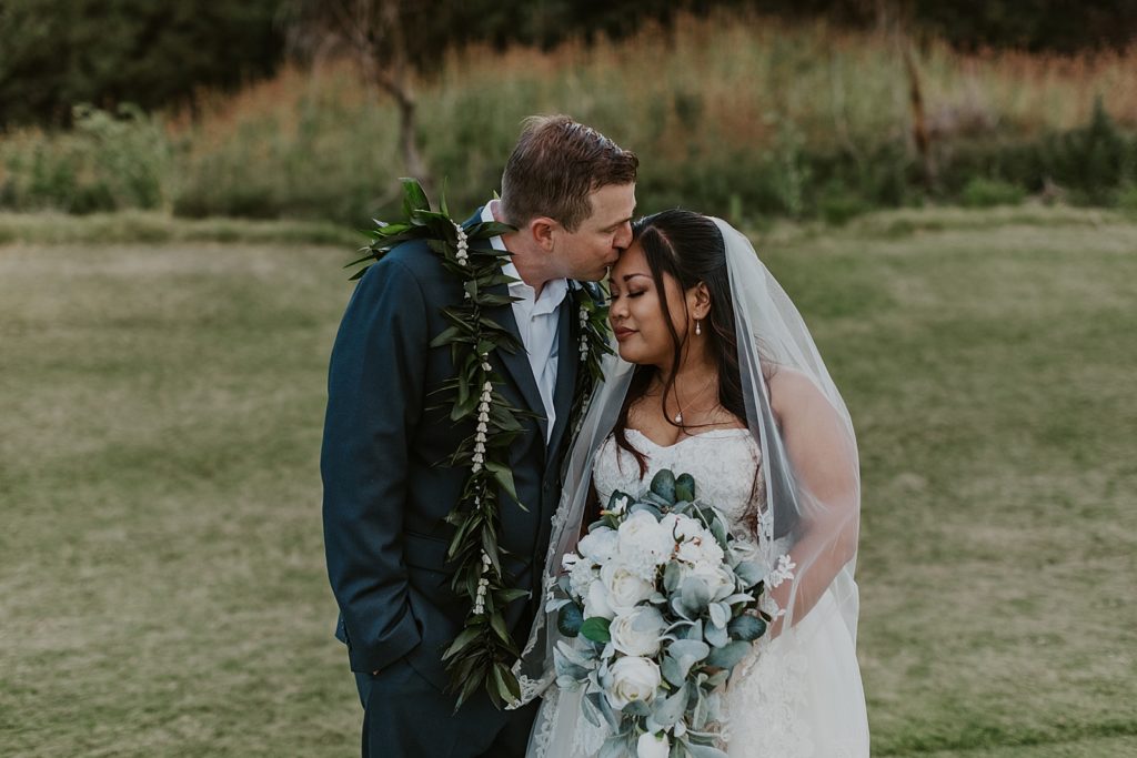 Groom kissing Bride on the forehead