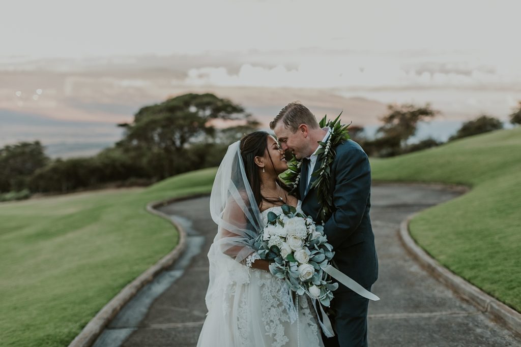 Bride and Groom nuzzling their noses on the golf course