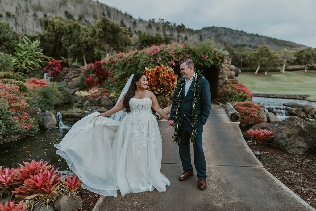 Bride and Groom holding hands on sidewalk together