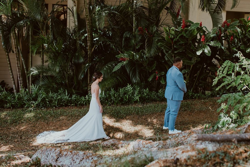 Bride approaching Groom in tropical green area for First Look
