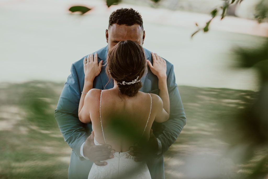 Portrait from tree of Bride and Groom kissing