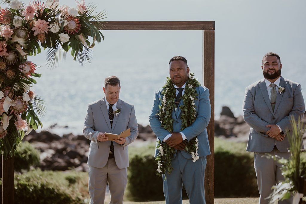 groom at arch alter awaiting Bride with officiant and Best man