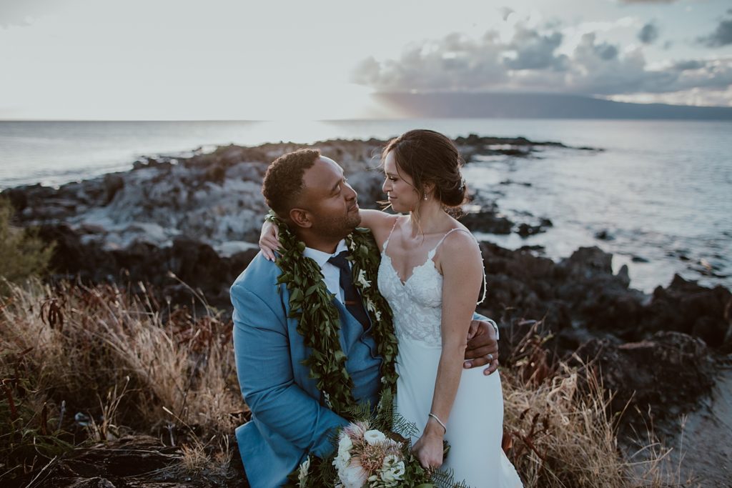 Bride leaning on Groom by the water