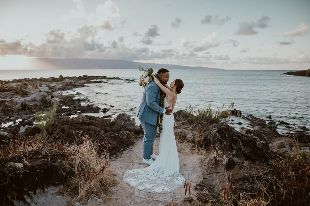Bride and Groom holding each other close by the water