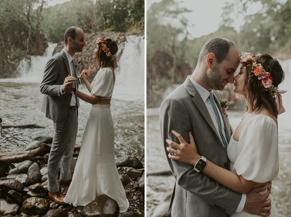 Bride and Groom looking at each other in front of forest waterfall
