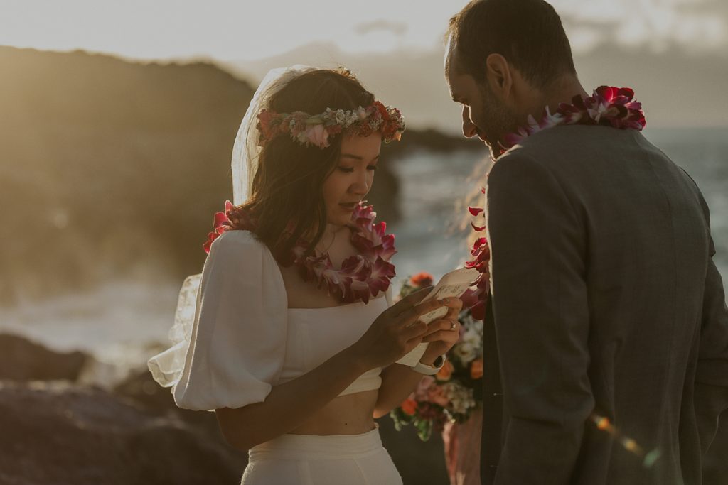 Bride reading vows to Groom with sun shining on them