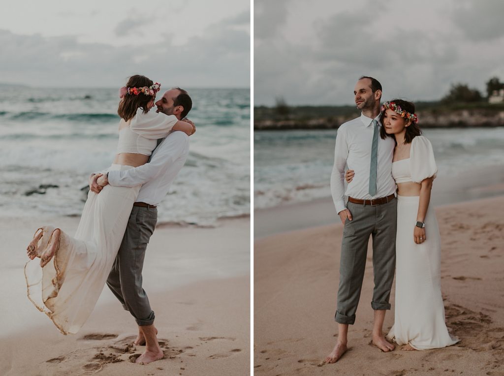 Groom lifting Bride up on sand in ocean wave coming in