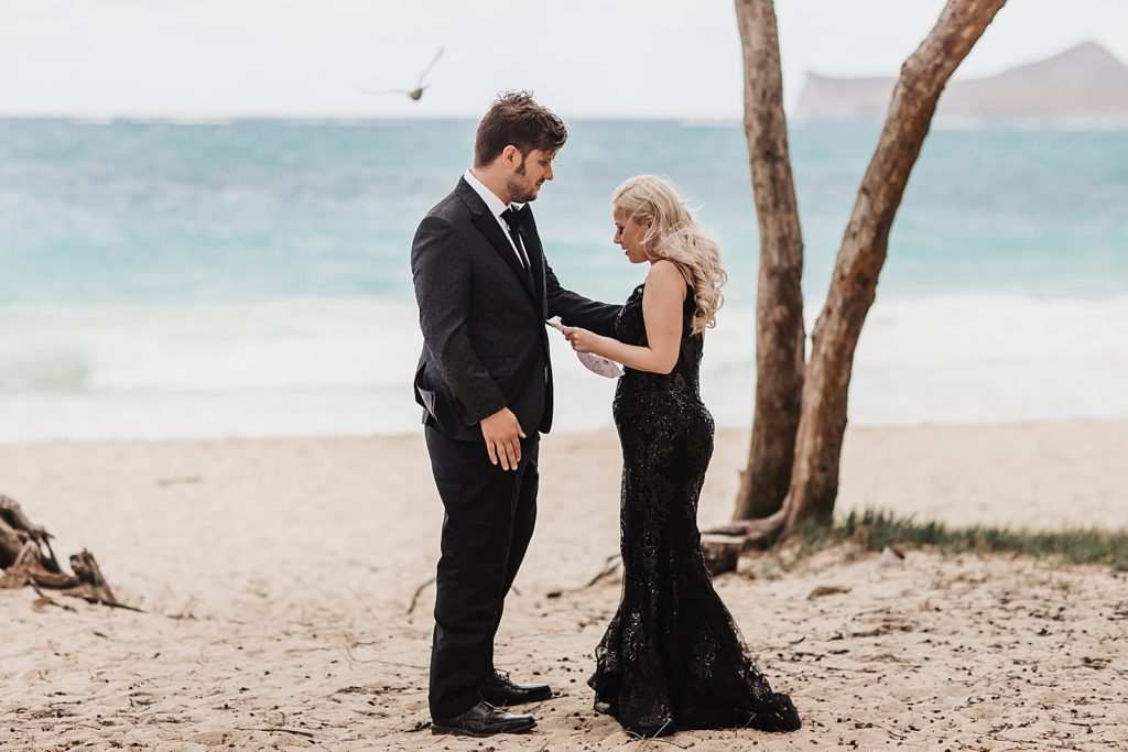 Bride and Groom on the sand reading vows