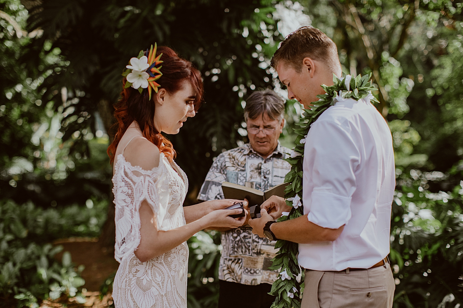 Bride and Groom taking rings out of boxes in front of officiant