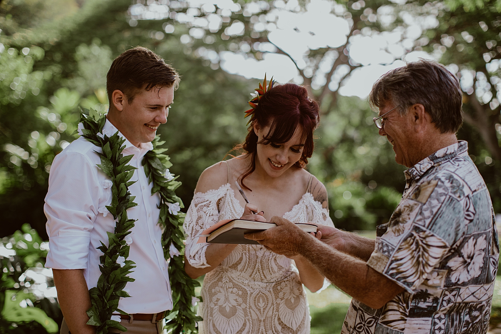 Bride and Groom signing certificate with officiant after Ceremony