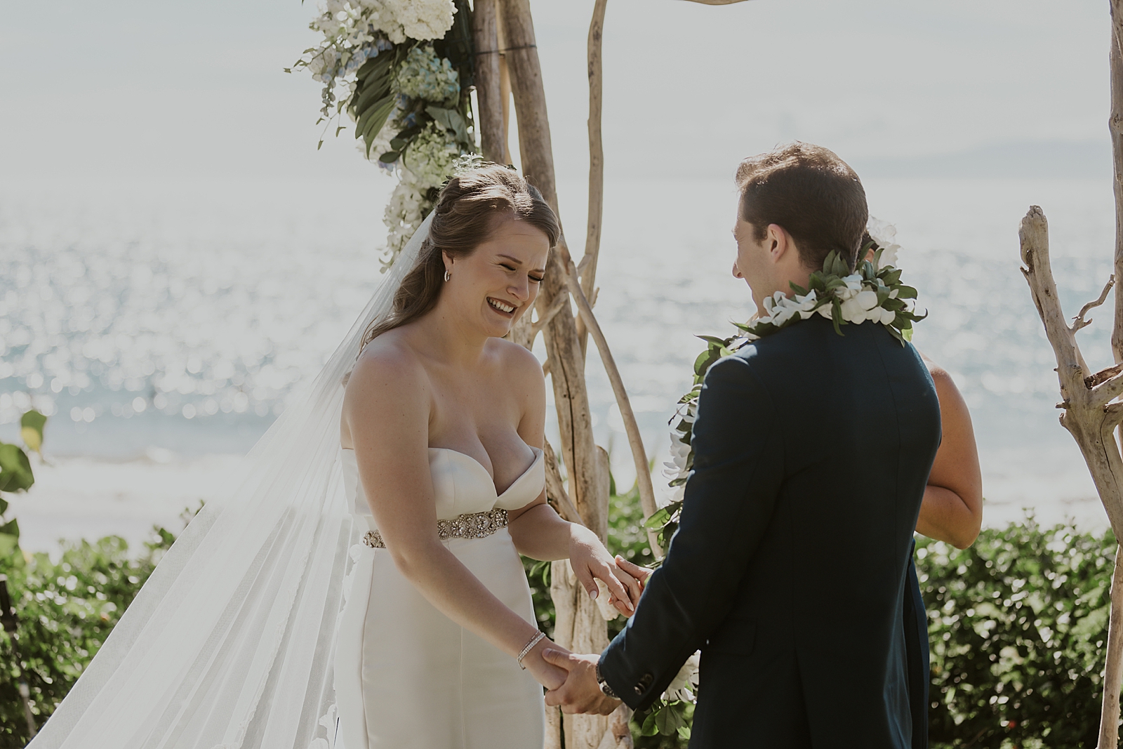 Candid shot of Bride smiling during Ceremony holding Groom's hands