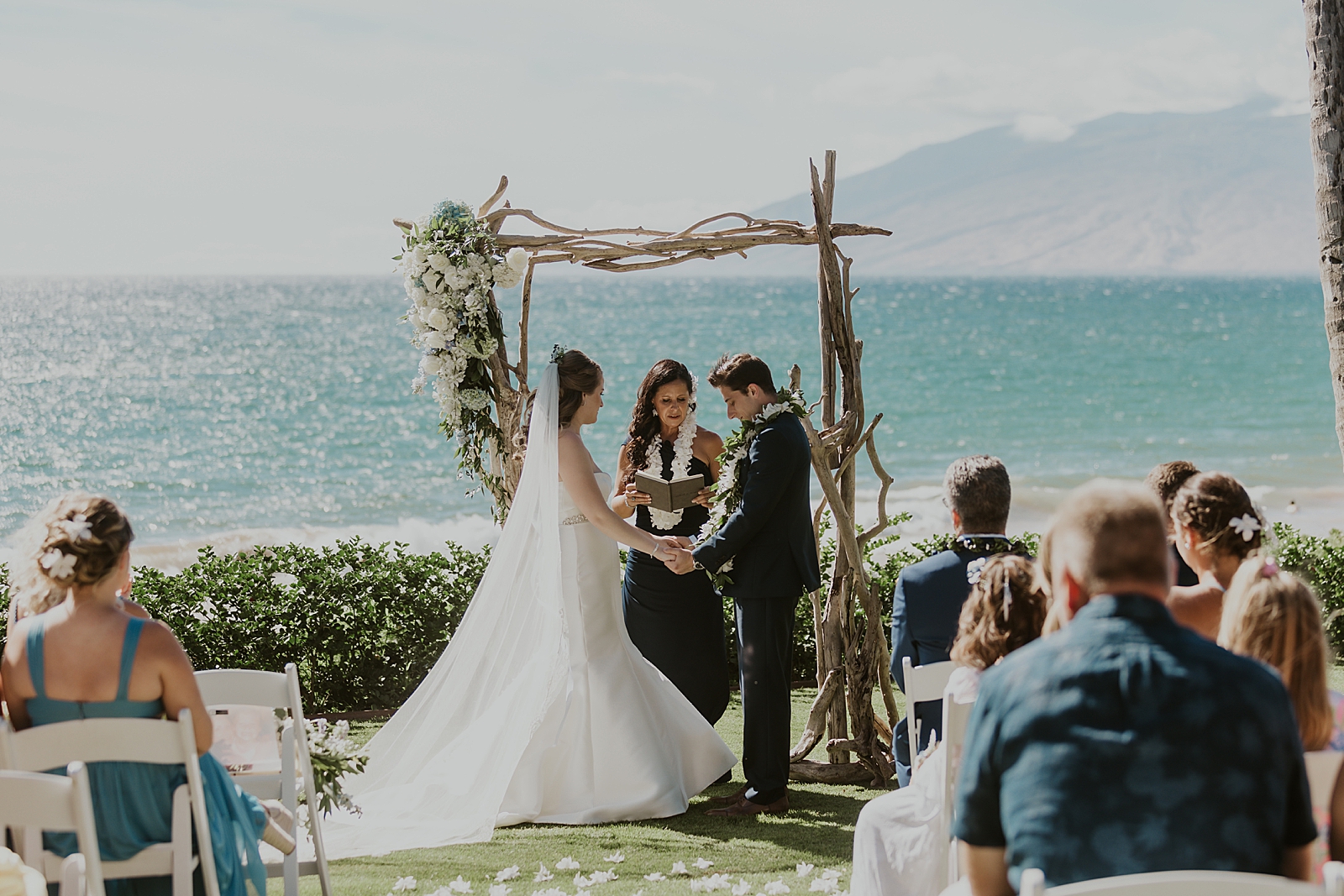 Bride and Groom hand in hand for outdoor Ceremony by the ocean