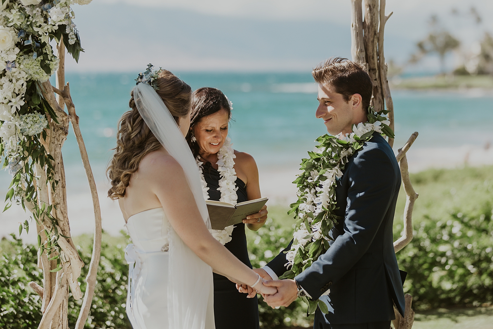Bride and Groom hand in hand for outdoor Ceremony by the ocean