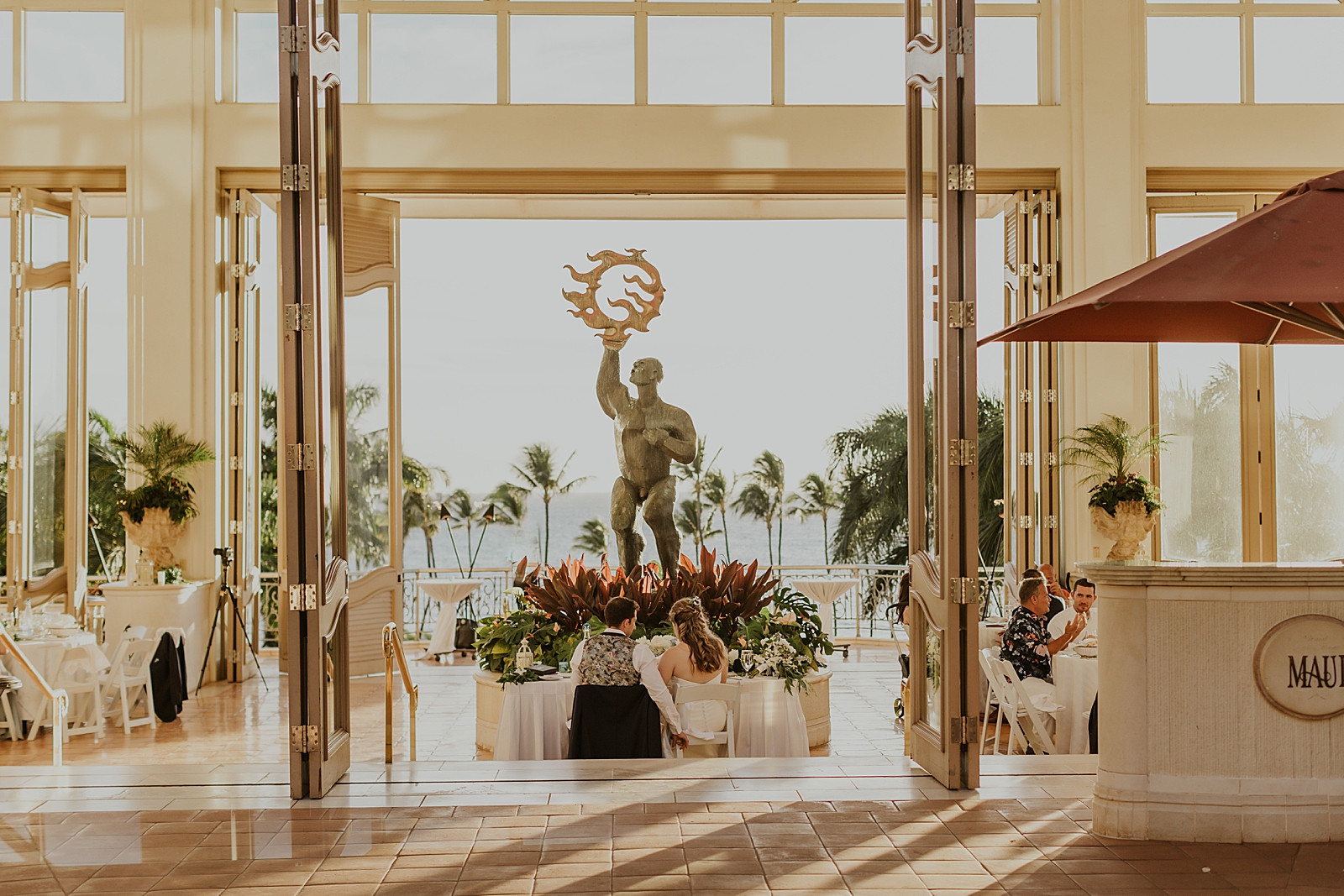 Detail shot of Greek statue and Bride and Groom sitting at sweetheart table