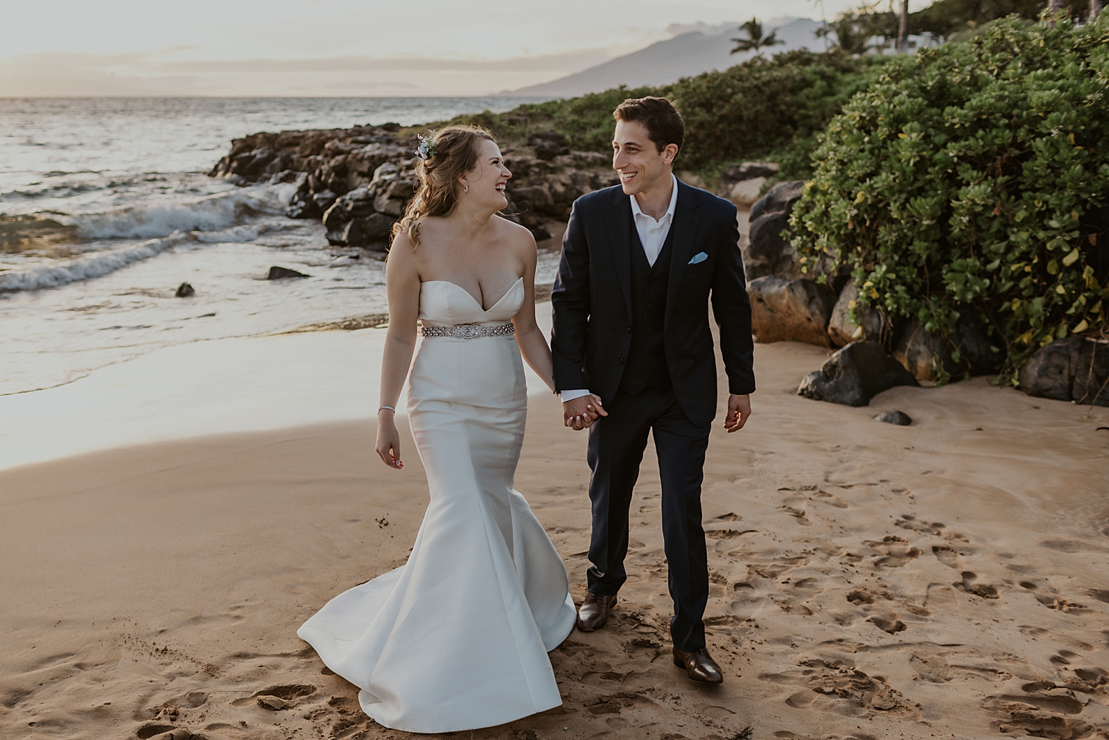 Bride and Groom holding hands and walking on the beach together