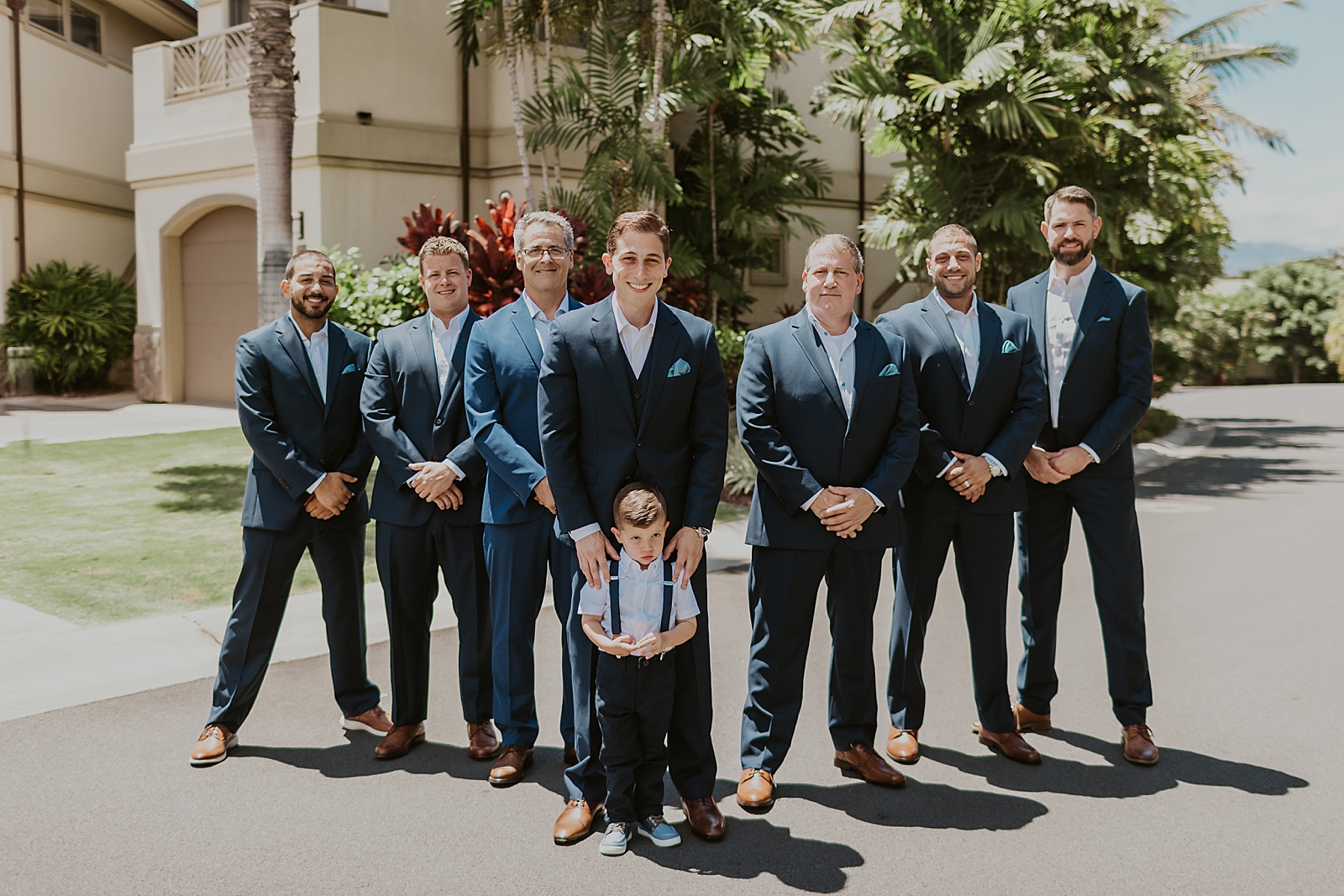 Groom holding ring bearer and Groomsmen in formation