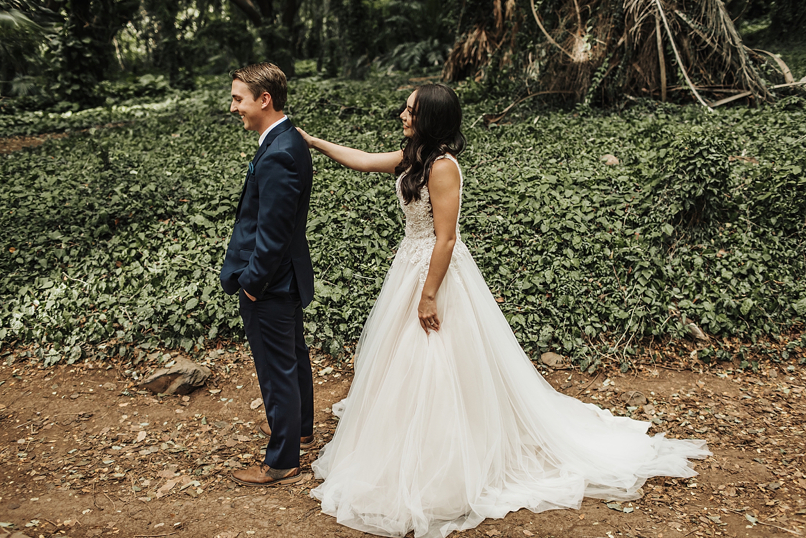 Bride tapping Groom on shoulder for first Look in forest