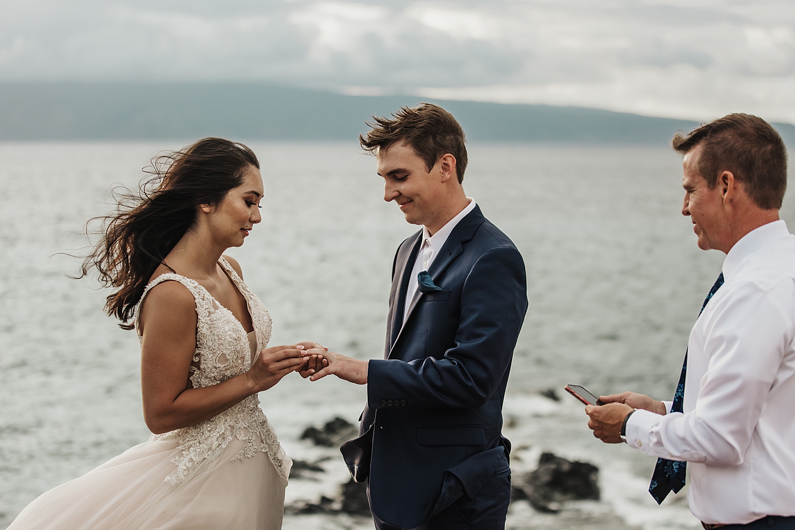 Bride putting ring on Groom for seaside Elopement