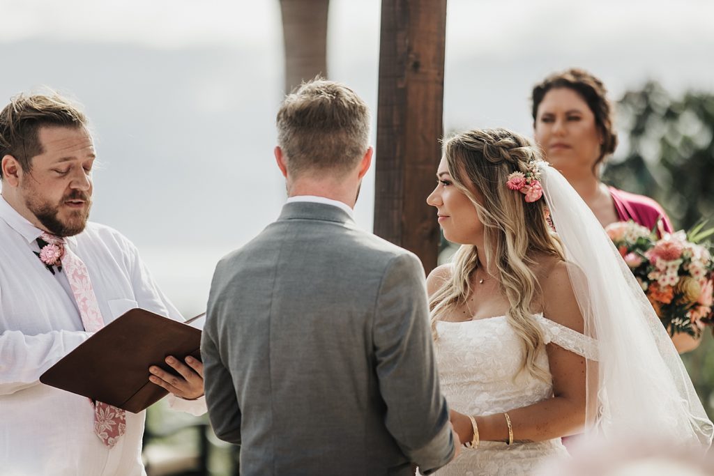 Bride and Groom watching officiant during Homily for outdoor Ceremony