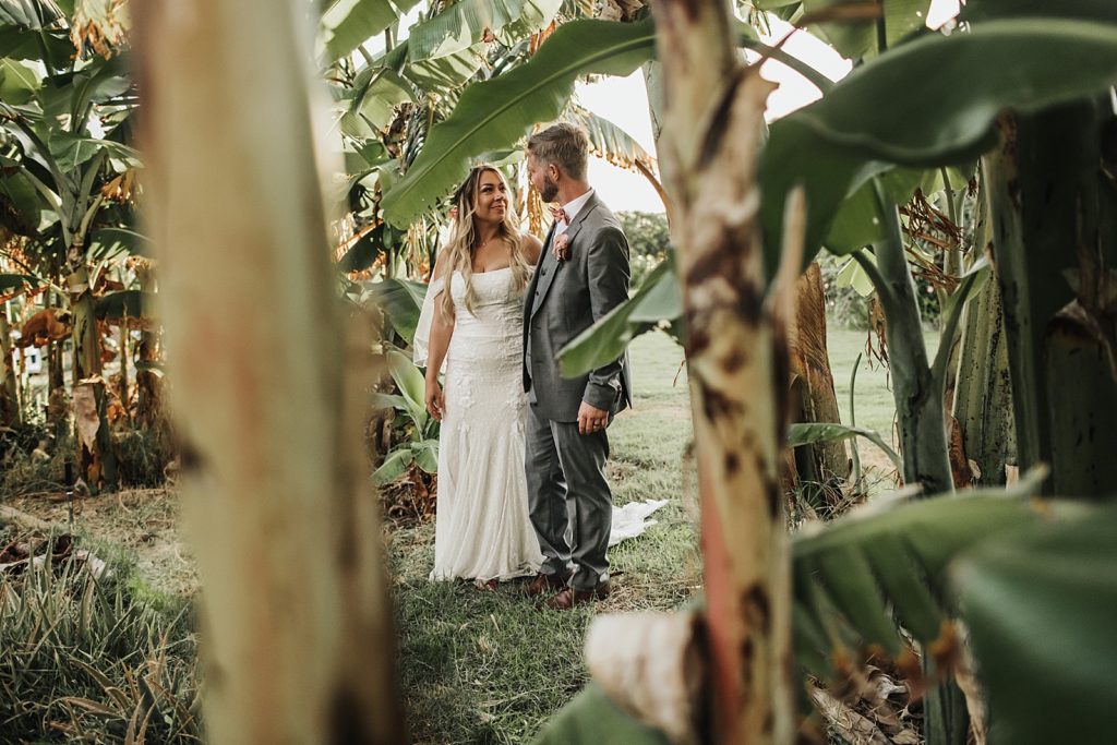 Bride and Groom looking at each other while in green trees around them
