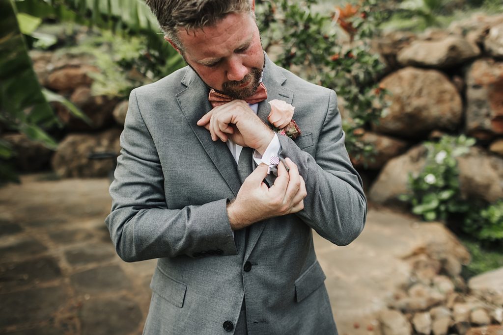 Groom adjusting cuff outside after getting ready