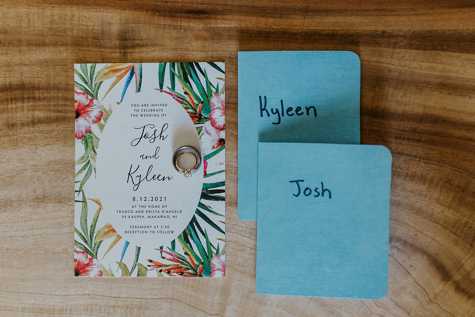 Detail shot of vow books invitation and wedding bands