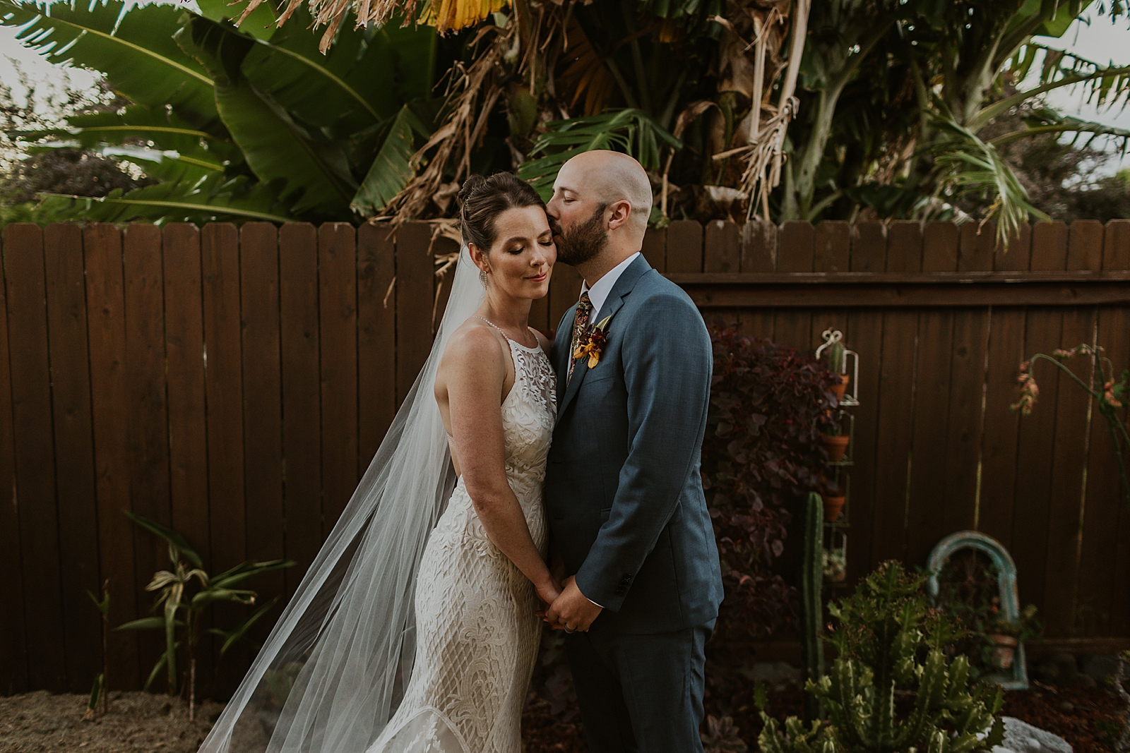 Groom kissing Bride on side of face portrait