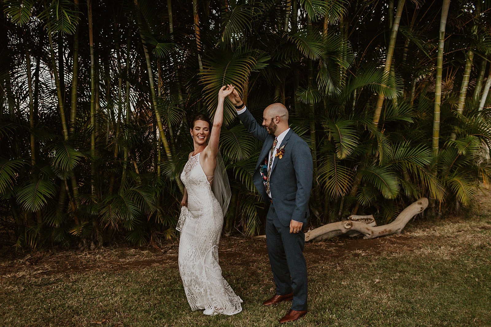 Bride twirling by Groom's hand by greenery