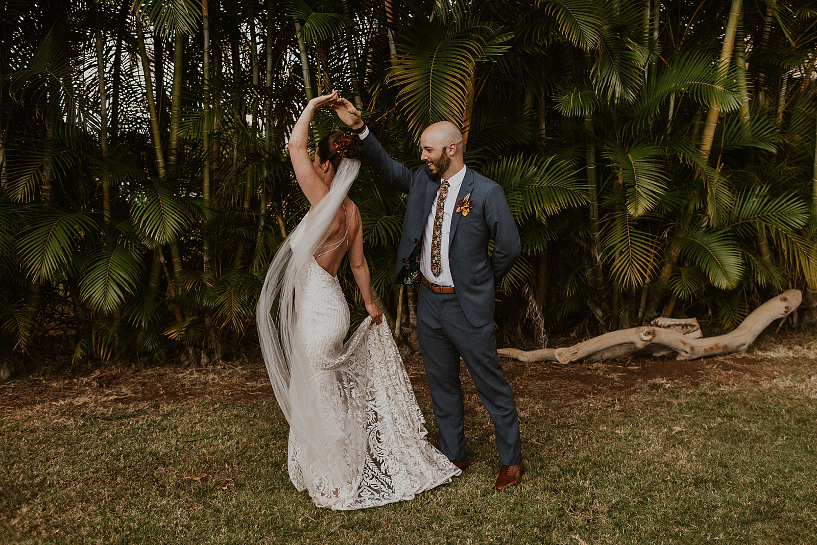 Bride twirling by Groom's hand by greenery