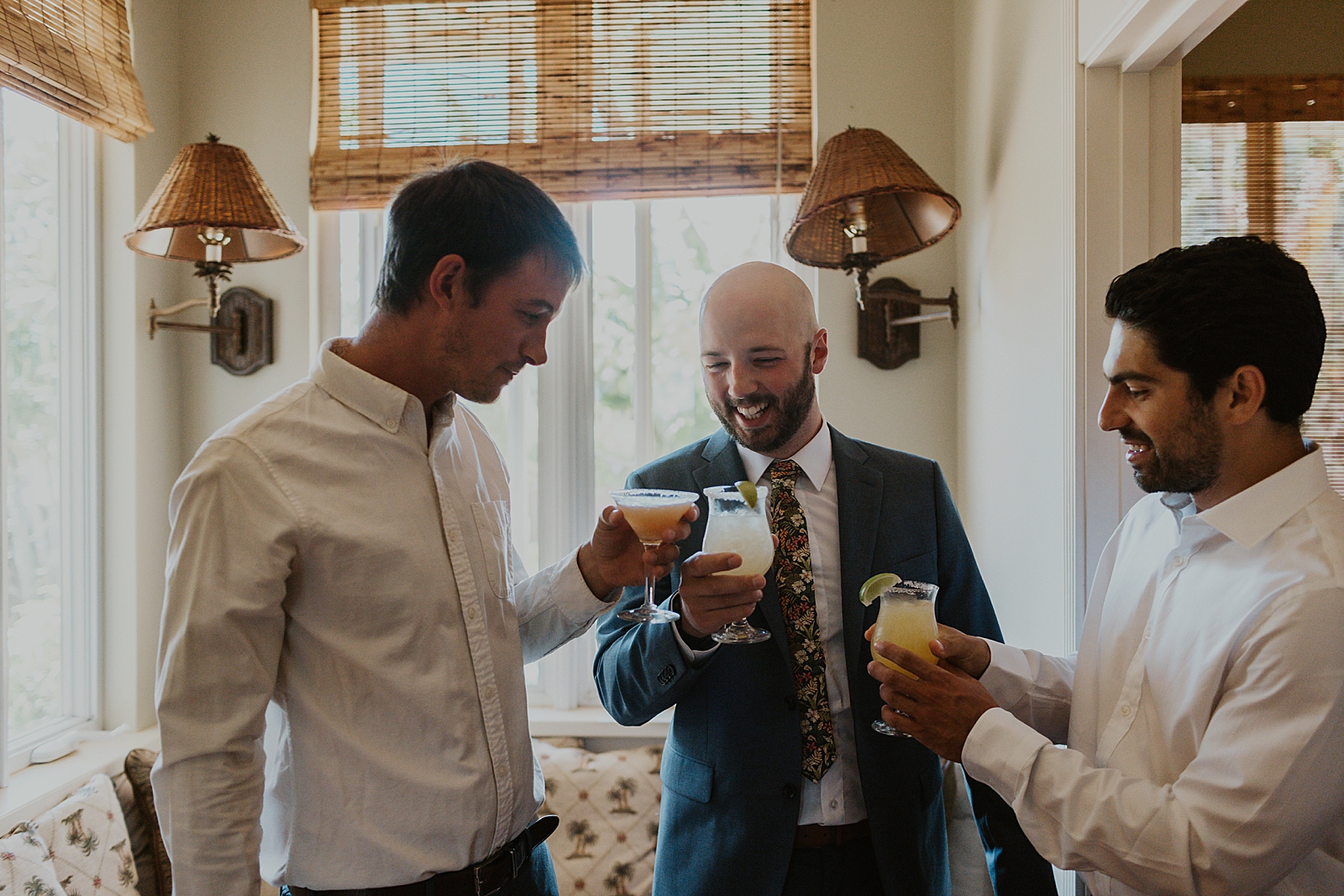 groom cheering cocktail drinks inside after getting ready