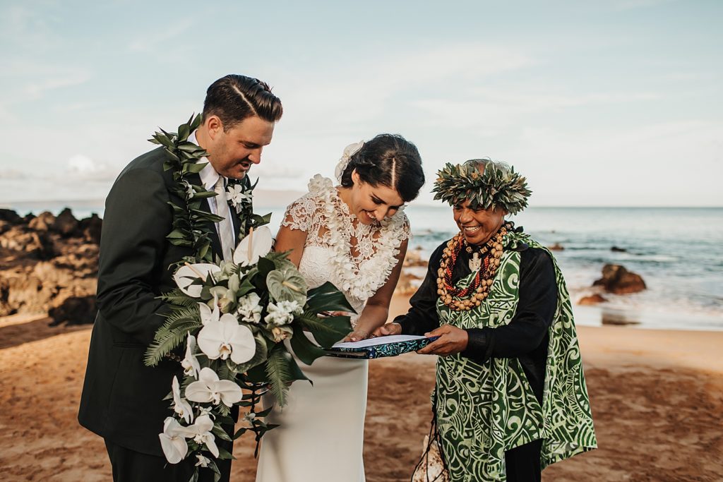 Bride and Groom signing papers with Officiant to make it official