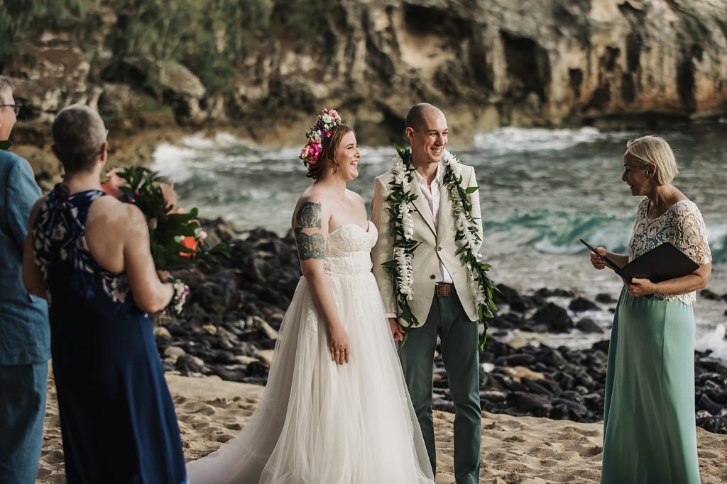 Bride and Groom hand in hand listening to officiant for beach elopement