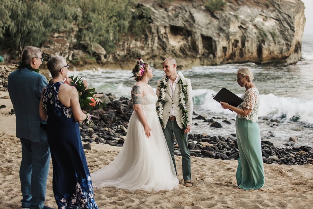 Bride and Groom hand in hand listening to officiant for beach elopement