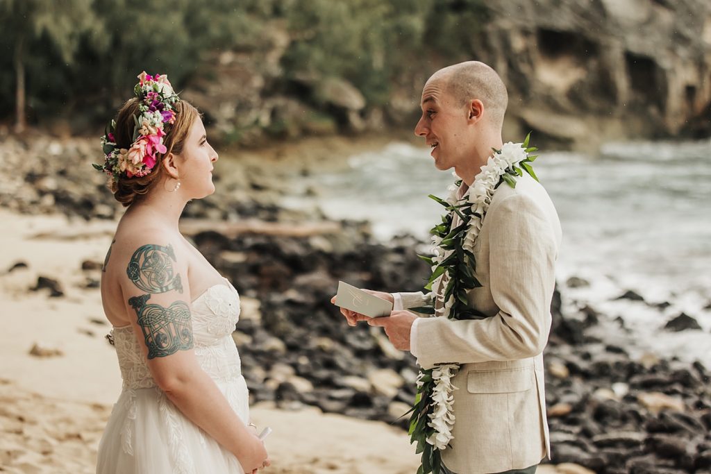 Groom giving vows to Bride on the sand by the ocean