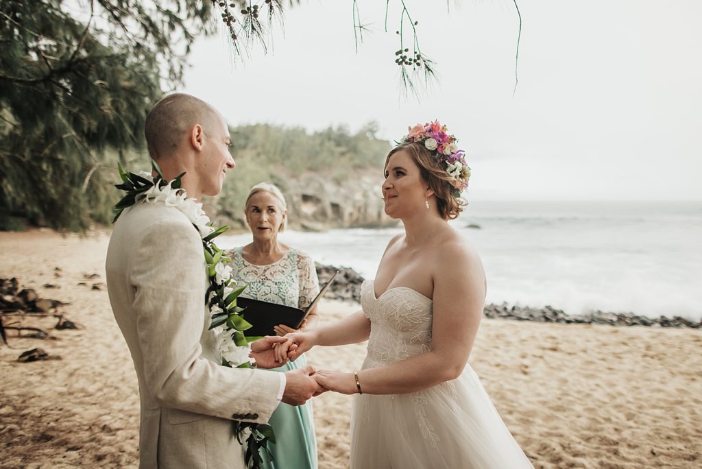 Bride and Groom listening to officiant on the beach