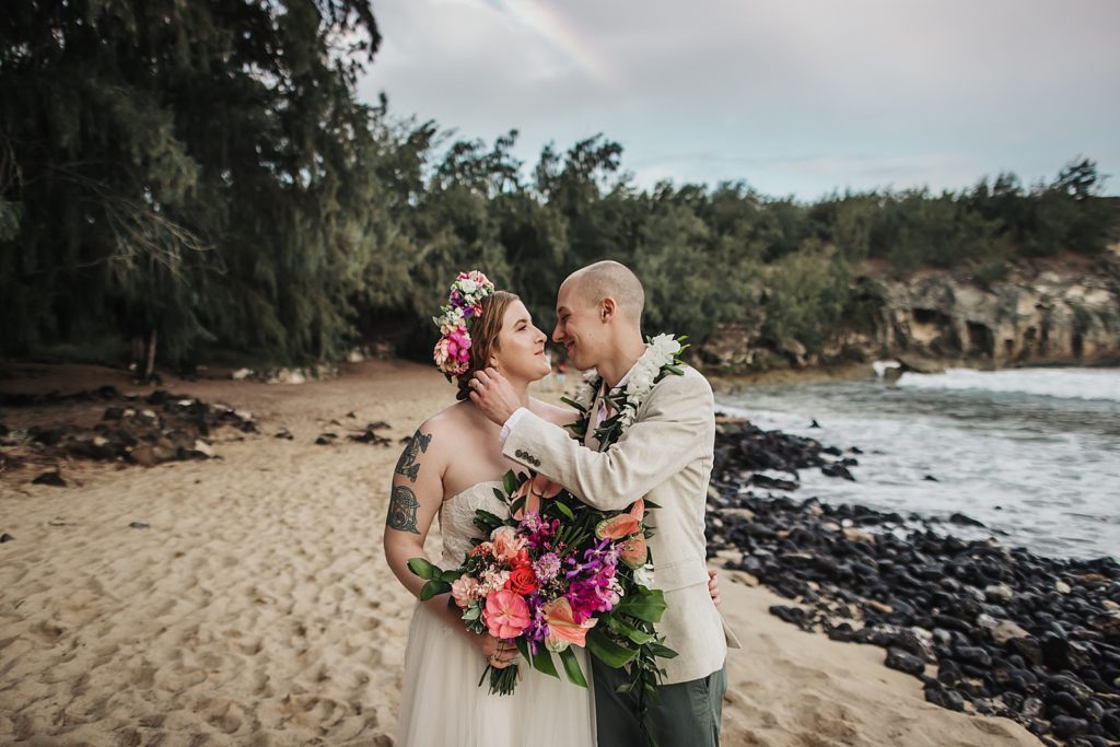 bride and Groom about to kiss while standing on the sand