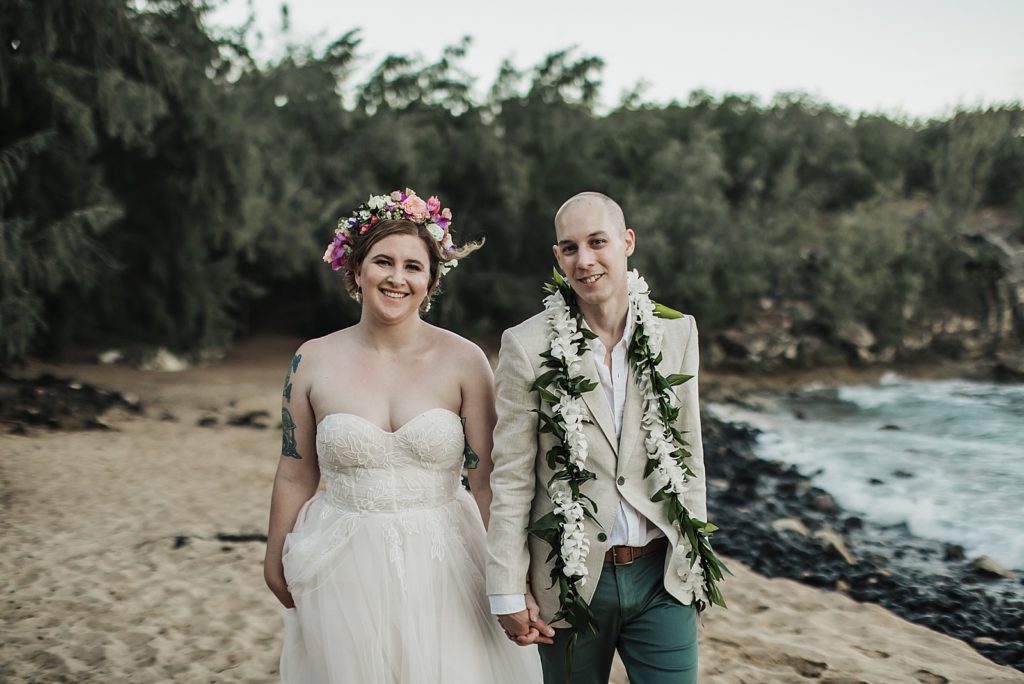 bride and groom holding hands on the beach