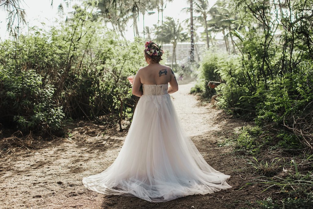 Bride walking down path by greenery