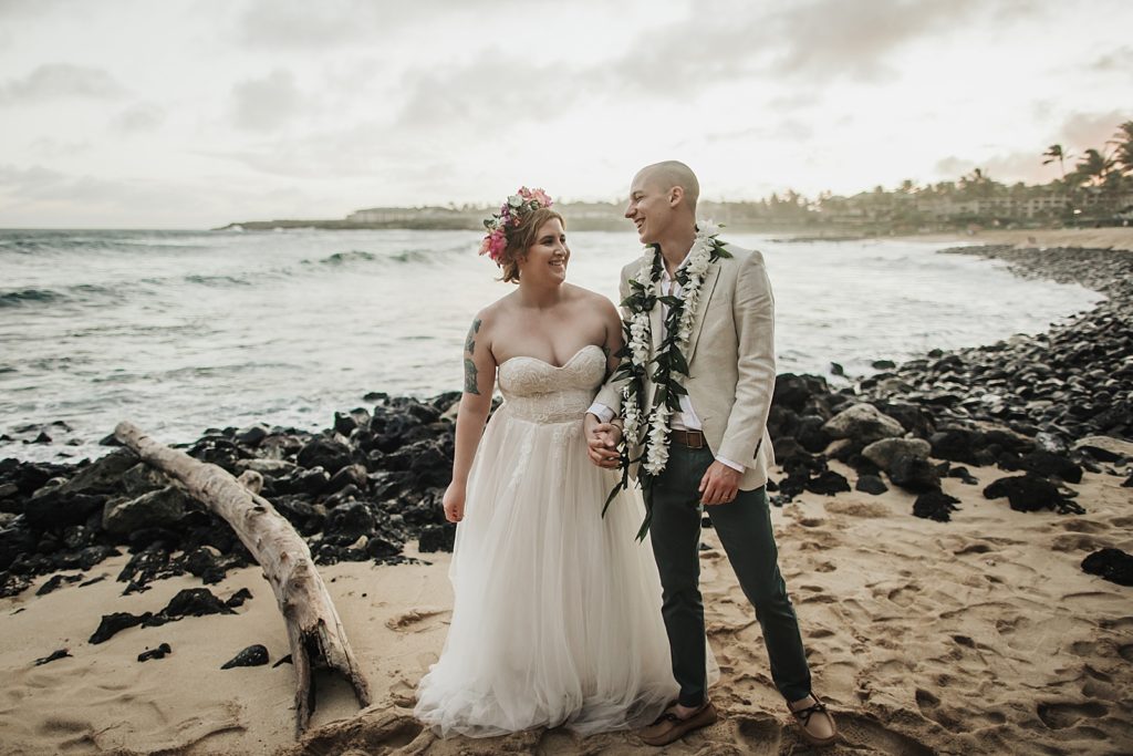 Bride and Groom holding hands and walking on the beach together
