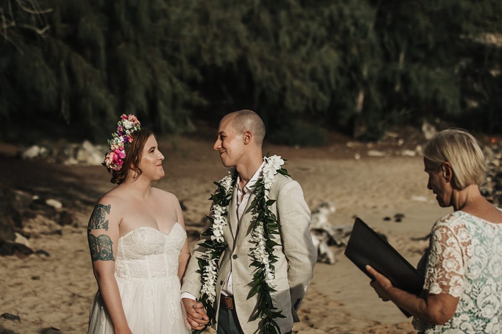 Bride and Groom looking at each other standing on the sand
